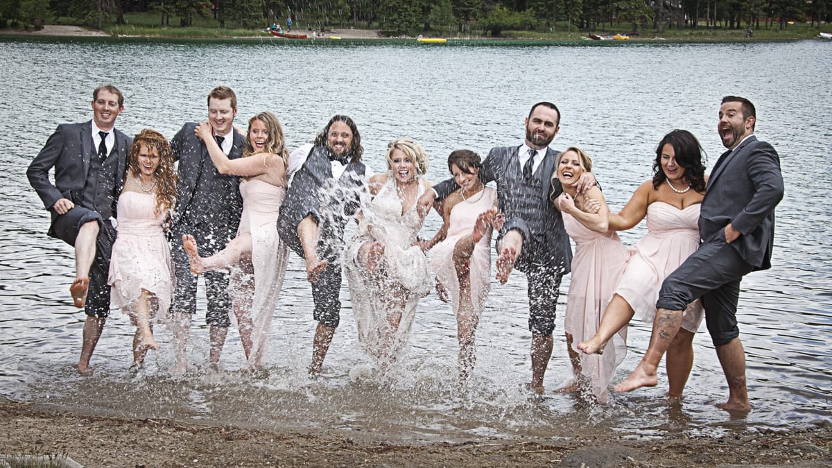 wedding party kicking up water at Lake Annette in Jasper