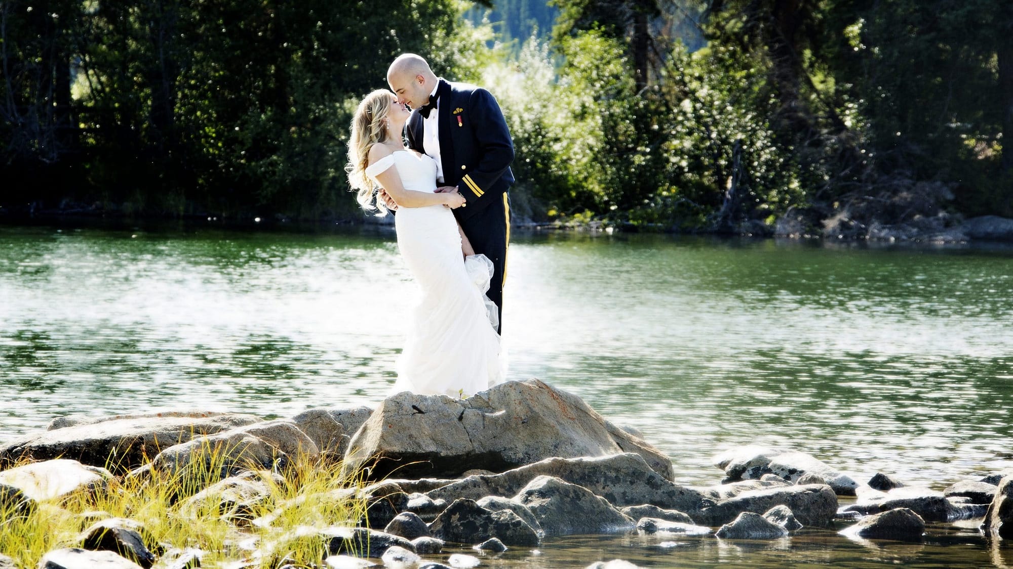 Bride and groom kiss while standing on rocks on Pyramid Island | Jasper photographers