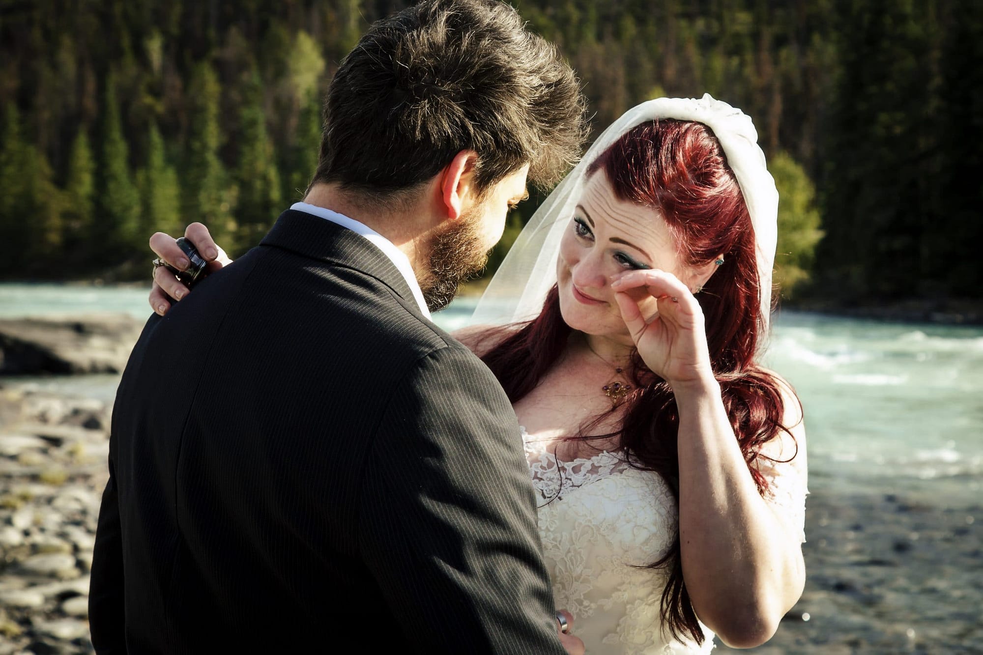 bride and groom exchanging a tender moment by athabasca river- getting married in Jasper