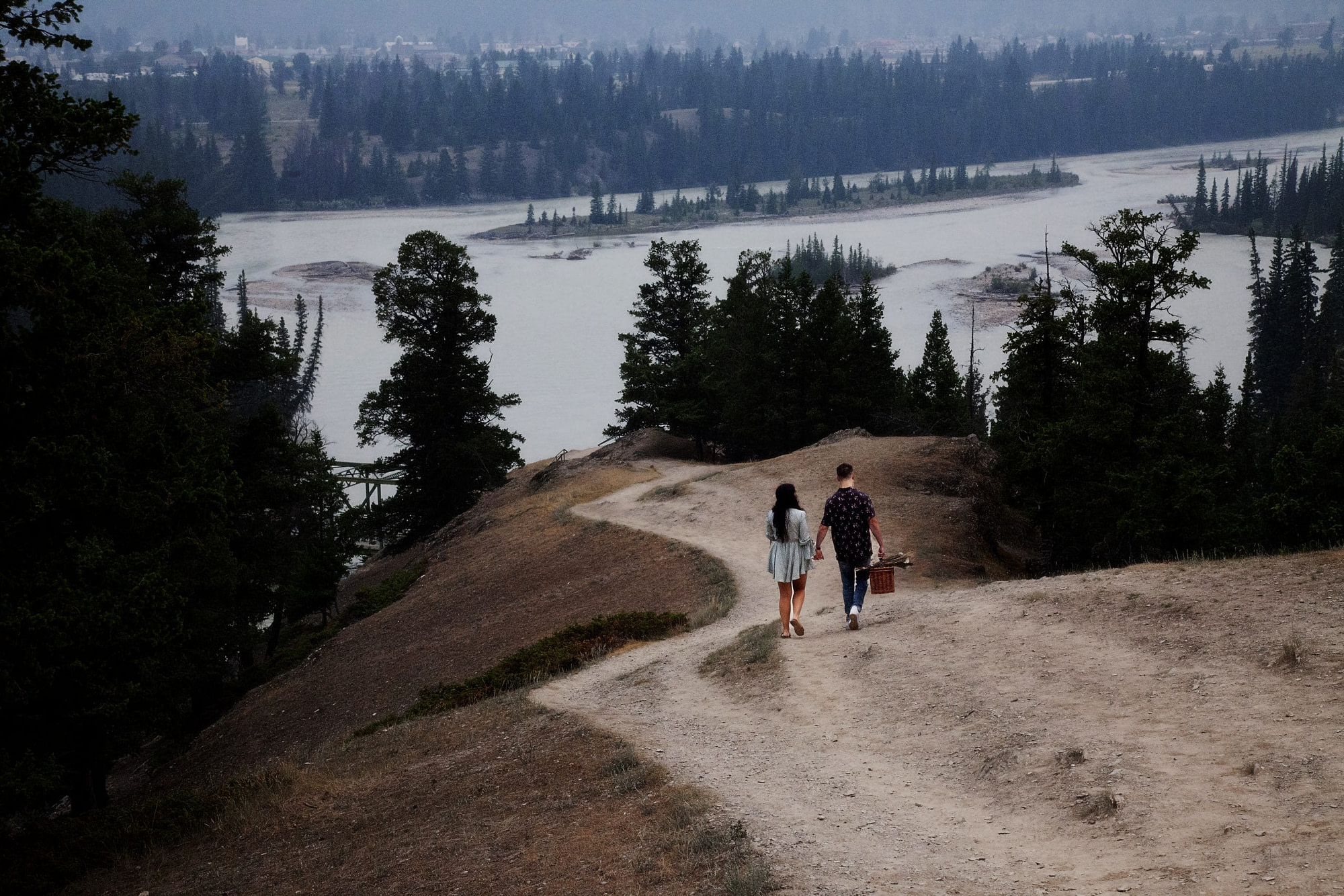 man and woman descending hill from behind at Old Fort Point Jasper -enagement photography Jasper