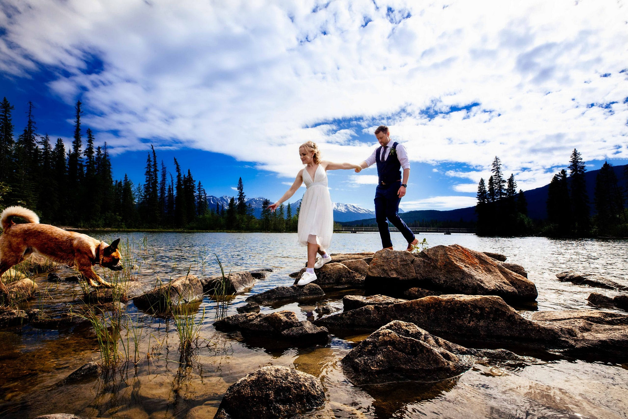 bride leading groom across rocks on Pyramid Island | Jasper Elopement Packages