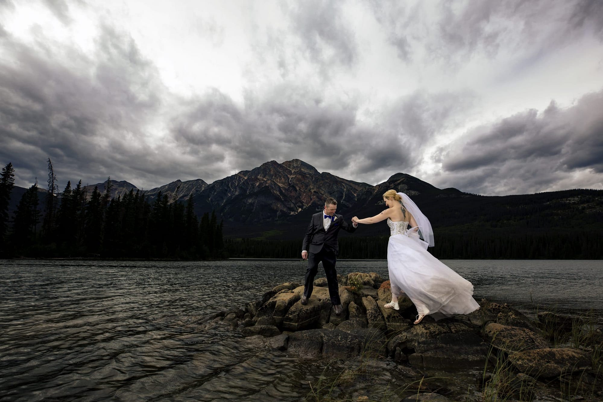 wedding couple walking on rocks on Pyramid Lake
