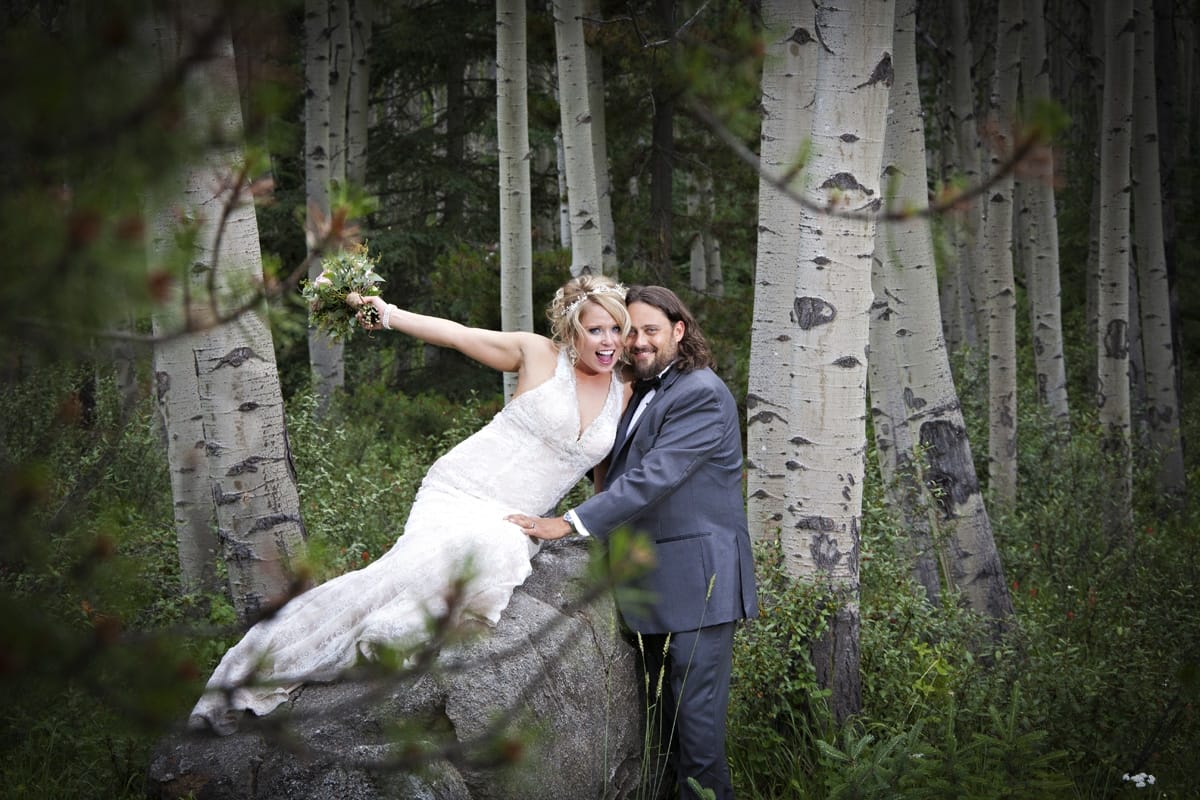 wedding couple sitting on a rock in poplar trees