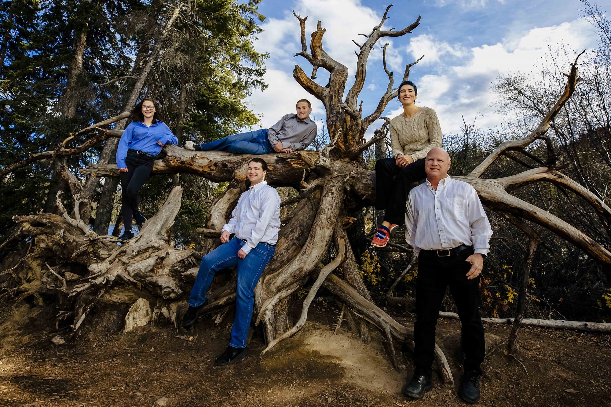 family of 5 posing in a tree root on Pyramid Island | Jasper photogrpaphers
