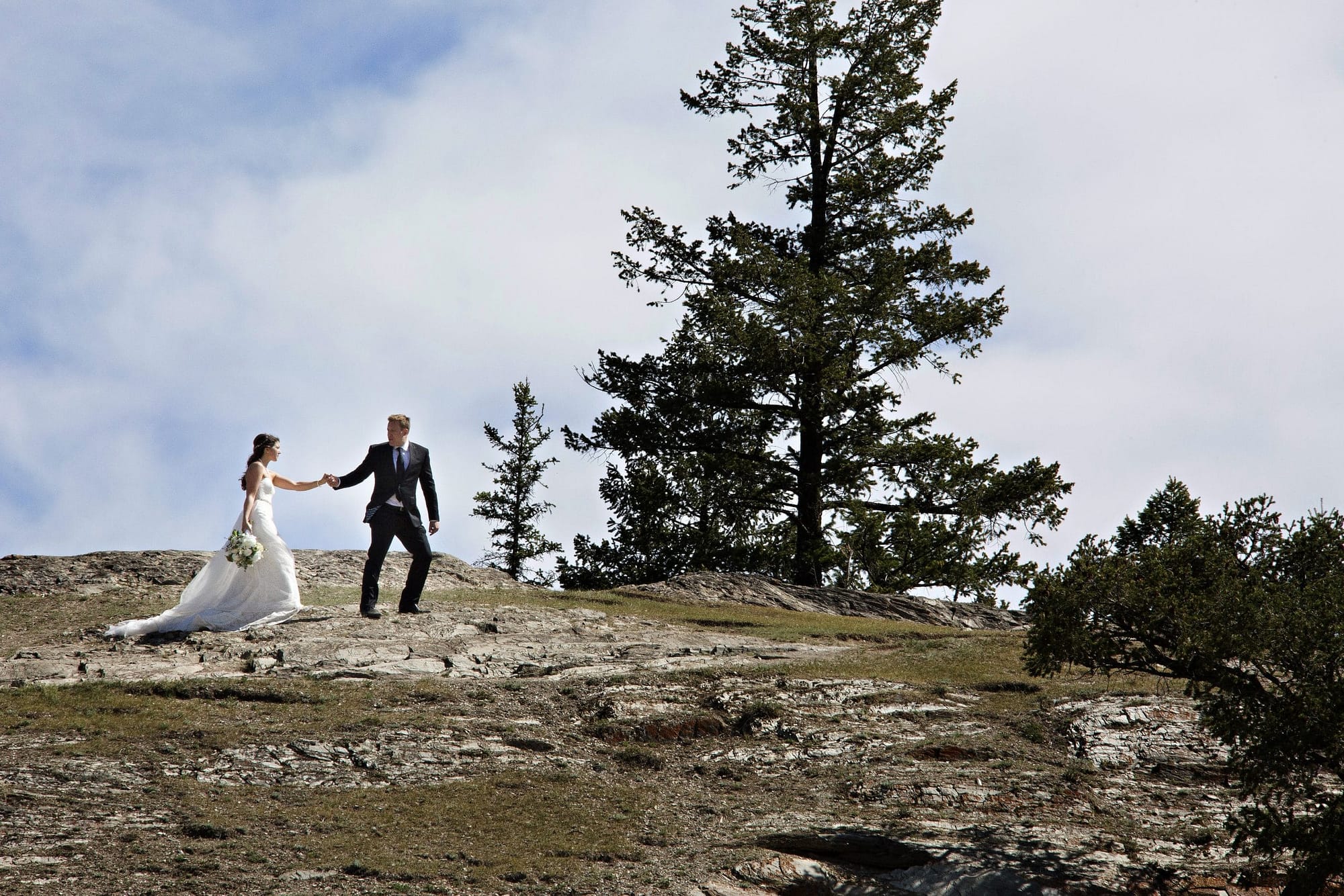 wedding couple walking on top of old fort point in Jasper