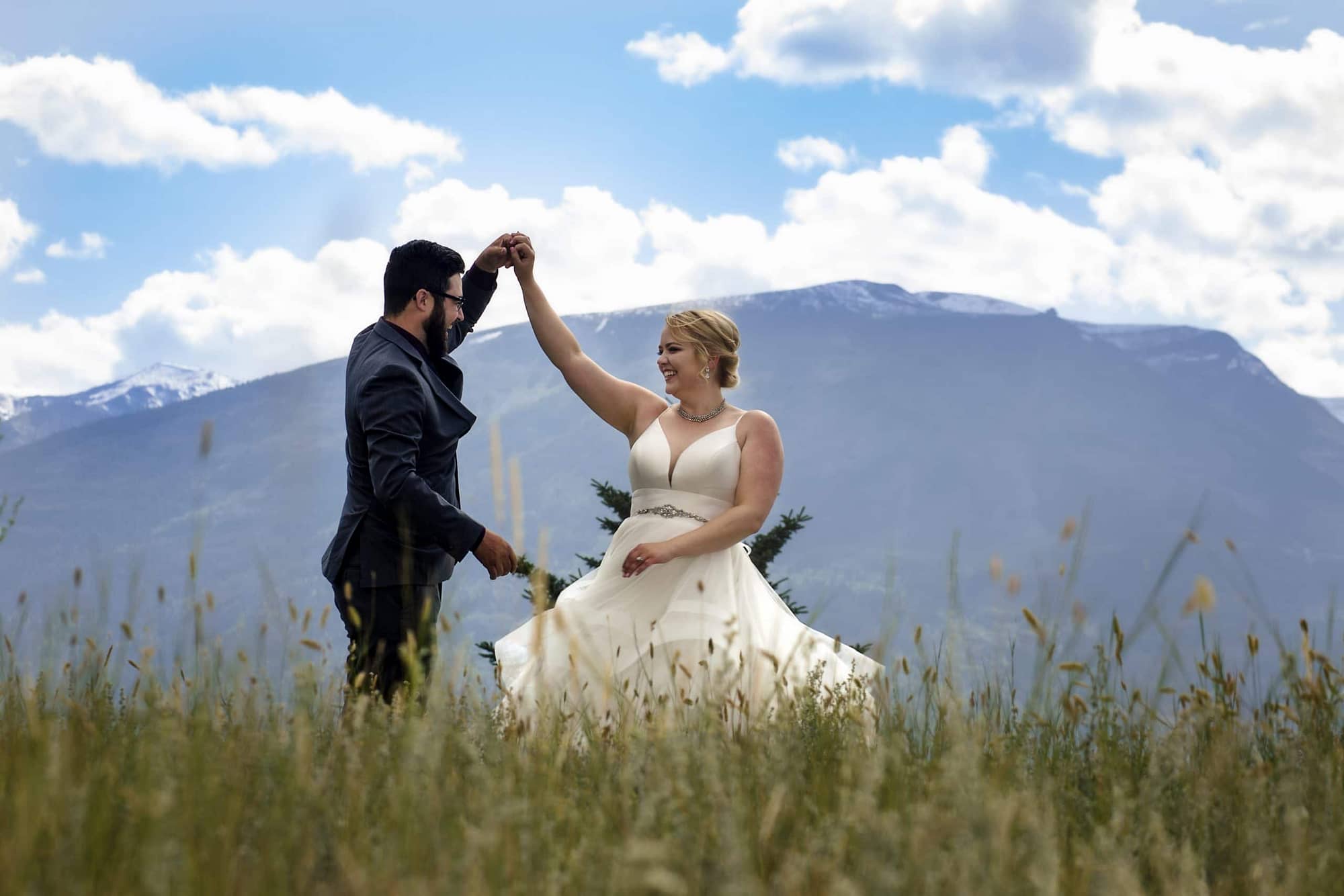 Bride and groom dancing in a meadow